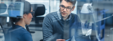 male businessman with glasses looking at a female business person